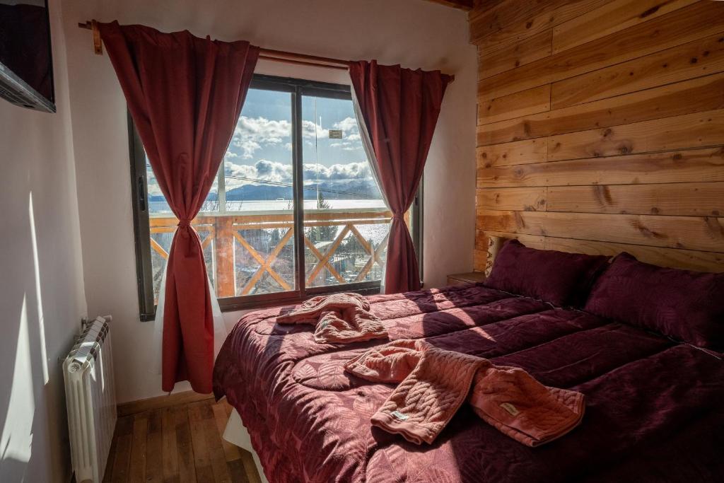 圣卡洛斯-德巴里洛切Dpto tipo cabaña con vista al lago的一间卧室设有一张床和一个大窗户