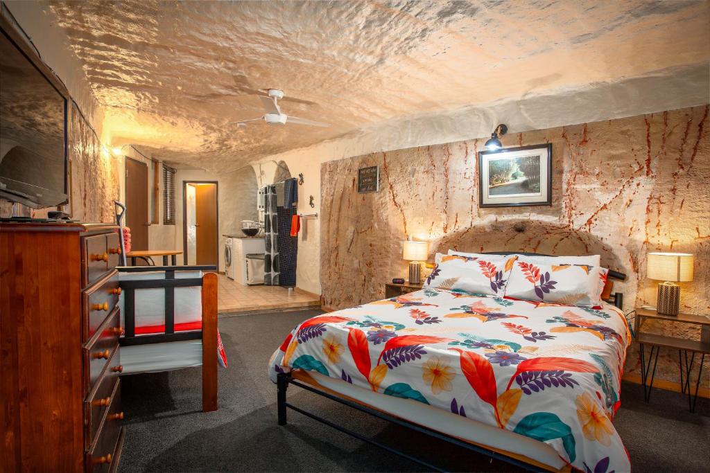 库伯佩迪盯奇迪杜古度假屋的一间卧室设有一张床和石墙