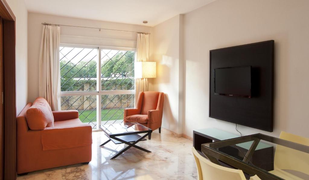 塞维利亚维尔缇切比伯兰布拉公寓的客厅配有2把椅子和平面电视
