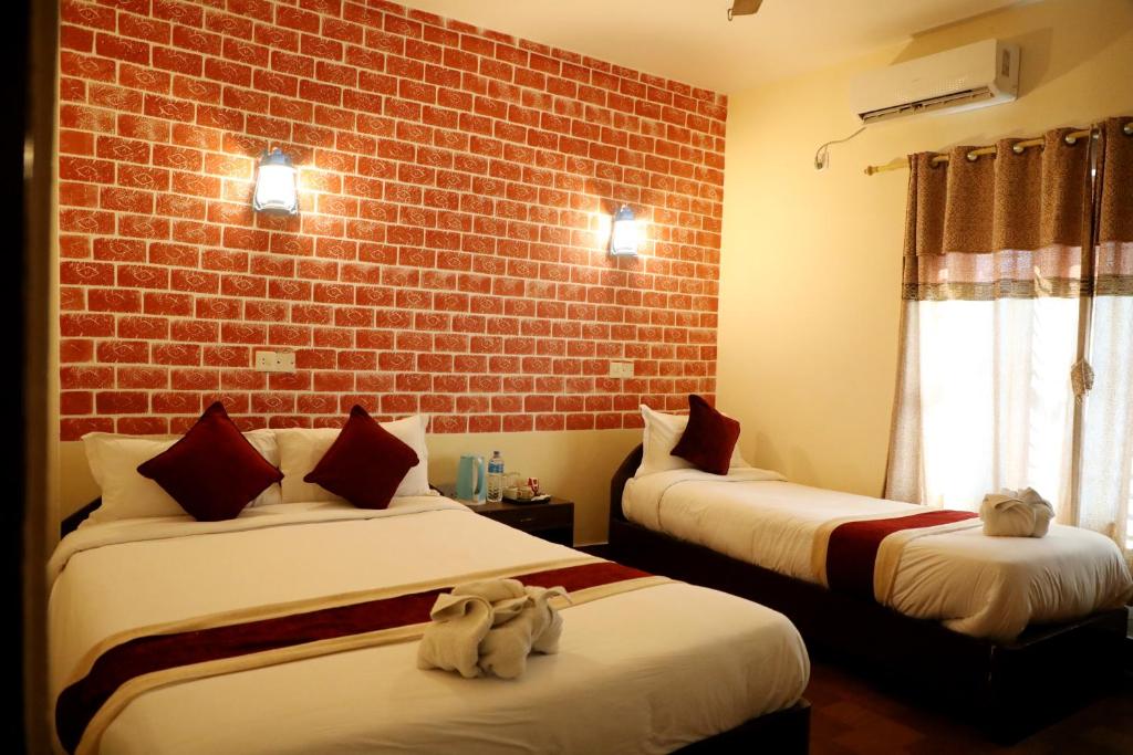 索拉哈Hotel Vista Chitwan的砖墙客房的两张床