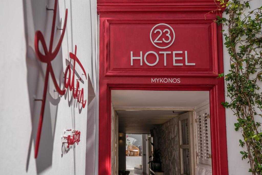 米克诺斯城23 Hotel Mykonos的大楼一侧的一个红色酒店标志