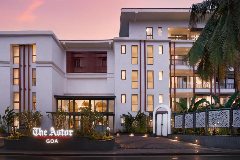 坎多林The Astor - All Suites Hotel Candolim Goa的黄昏时公寓大楼的 ⁇ 染