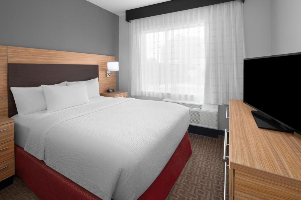 金斯维尔TownePlace Suites by Marriott Kingsville的配有一张床和一台平面电视的酒店客房