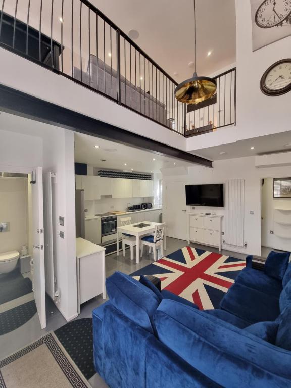 伦敦Deluxe Townhouse Zone 1 Brick Lane的一间带蓝色沙发的客厅和一间厨房