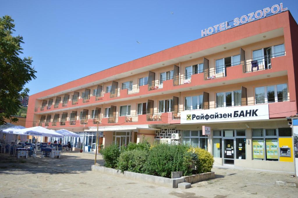 索佐波尔Hotel Sozopol的一座红色的大建筑,标有酒店标志