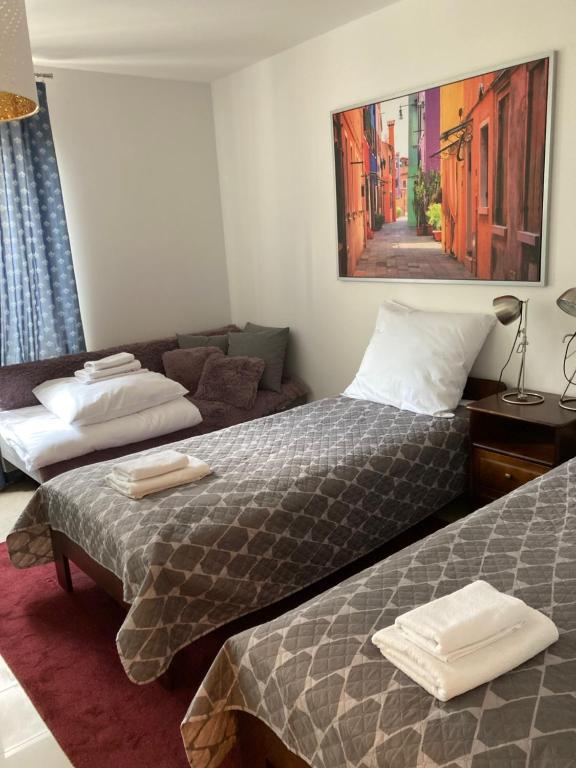 华沙Szucha Residence Apartments by Global Apart的酒店客房,设有两张床和一张沙发