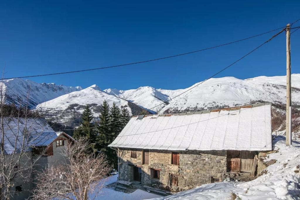 瓦卢瓦尔Chalet Chez Maxime Hameau l’Archaz Valloire的一座有雪覆盖的山的古老建筑