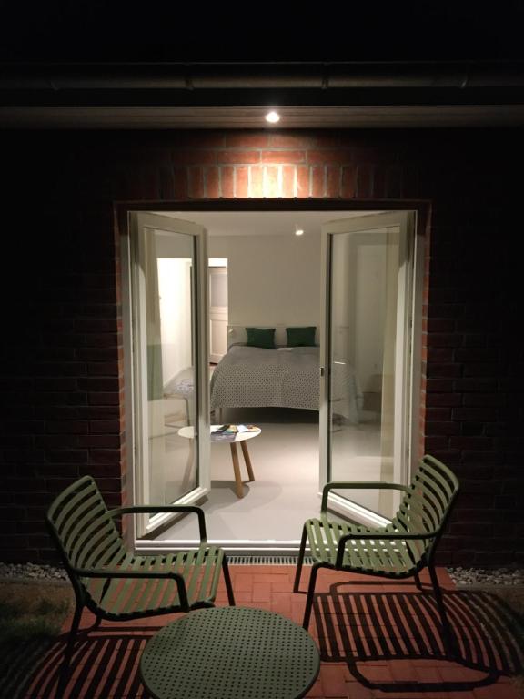 弗里克苏姆Nije Haven Bed & Breakfast的晚上在庭院里摆放两把椅子和一张桌子