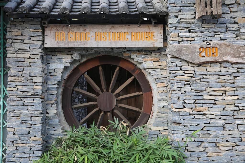 河江Ha Giang Historic House & tour的石头房子里一座带木轮的建筑