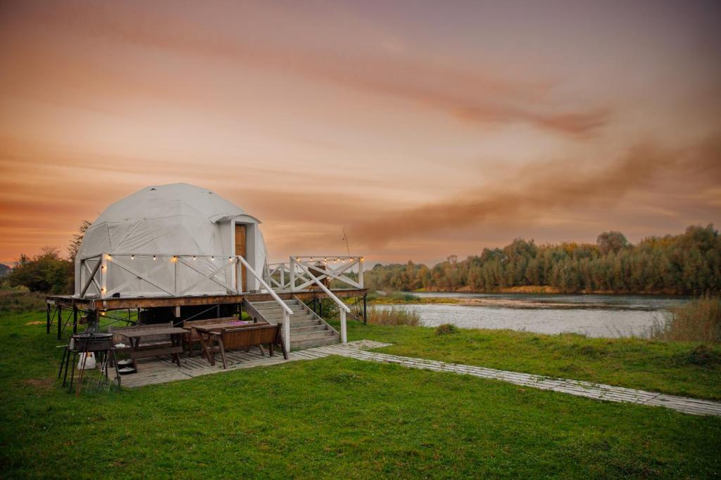 Готель Еко Сфера的湖畔码头上的圆顶帐篷