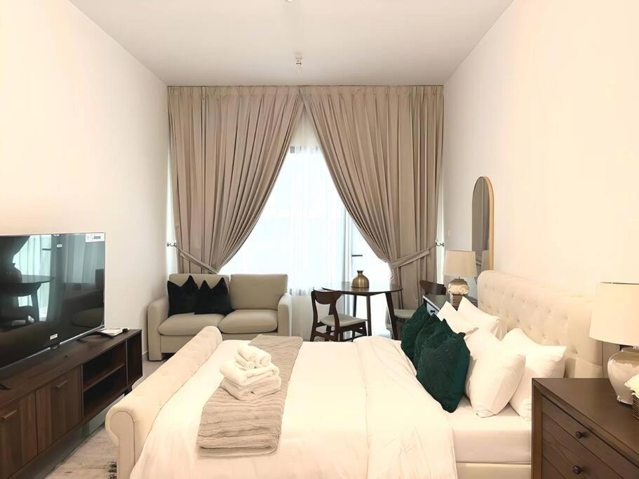 Al QurayyahClassy Studio in Masdar City的白色卧室设有一张大床和一张沙发
