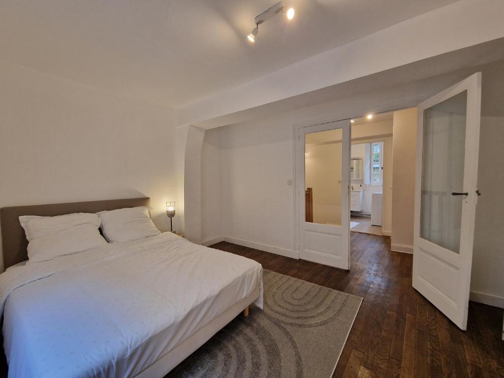 拉瓦勒Centre Historique LAVAL的卧室设有一张白色大床和一个走廊