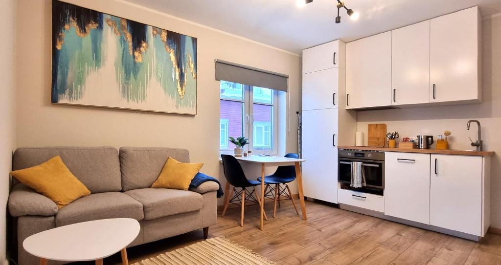 塔林Entire Apartment + 2 Rooms + Self Check-in的带沙发和桌子的客厅以及厨房。