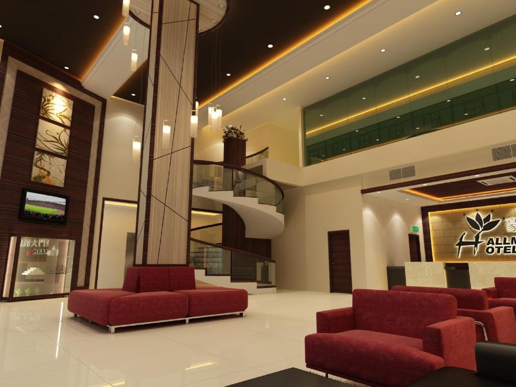 新山Hallmark Regency Hotel - Johor Bahru的大堂设有红色椅子和螺旋楼梯