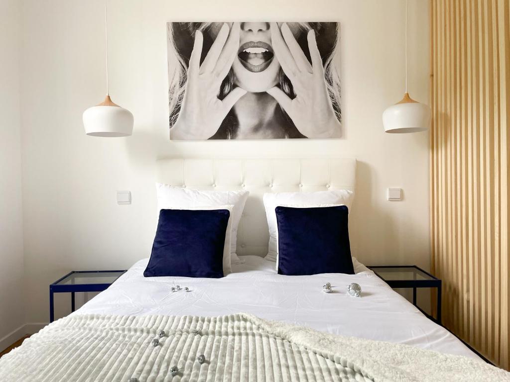 勒蒙多尔Appartement Rose velours的一间卧室配有一张带两个蓝色枕头的床