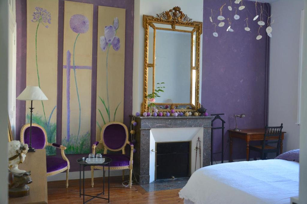 利布尔讷la maison的一间卧室设有壁炉、镜子和一张床