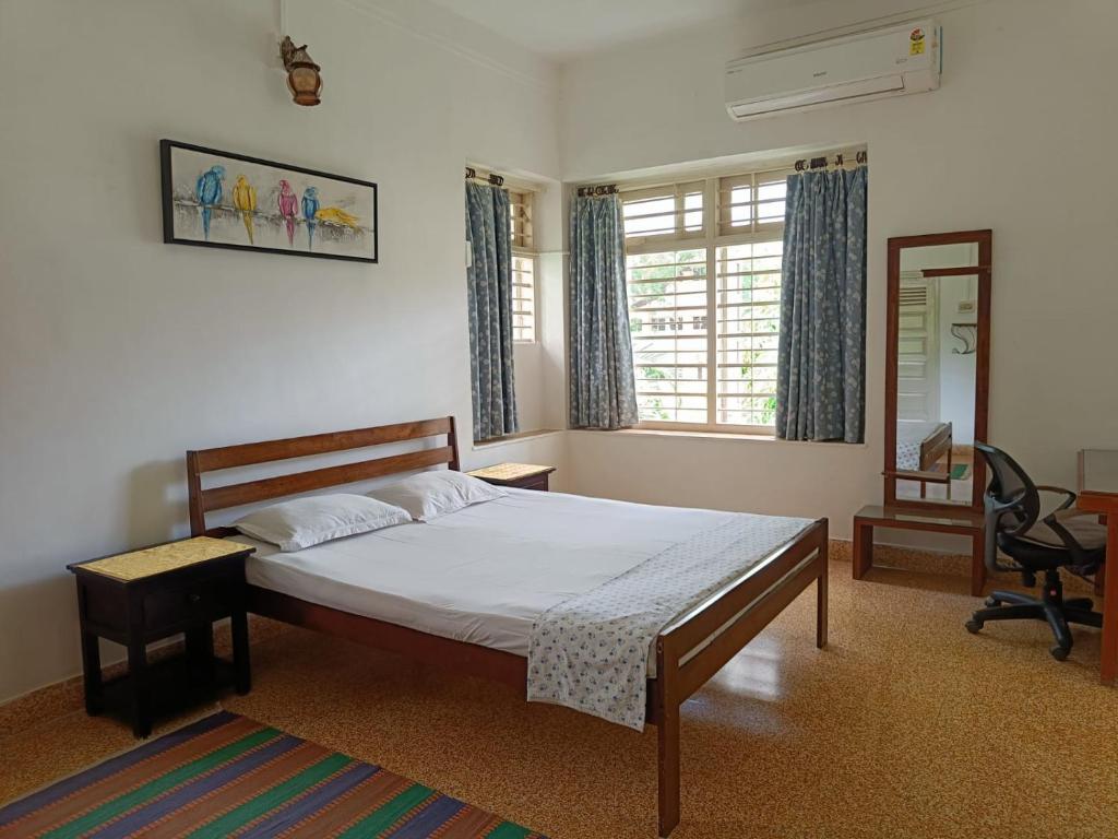艾哈迈达巴德Srinekatan Heritage Villa Homestay的一间卧室配有一张床、一张桌子和一把椅子