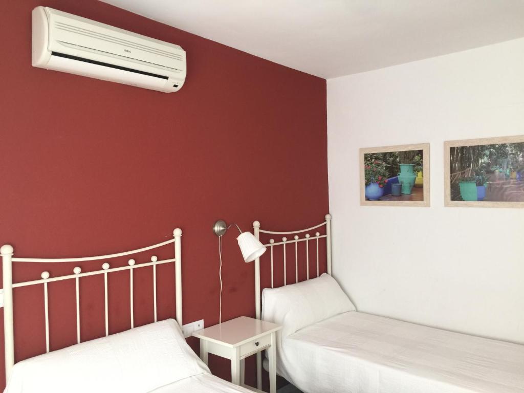 RocianaHostal Monteluna的红色墙壁客房的两张床