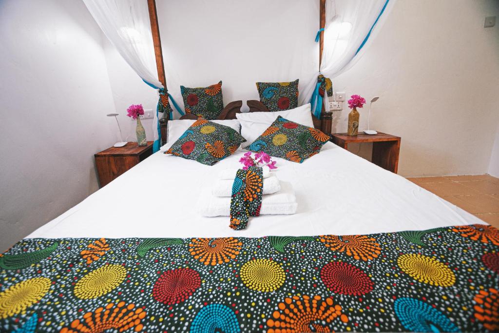 江比阿Cozy Lodge - Guesthouse的床上有五颜六色的毯子,上面有鲜花