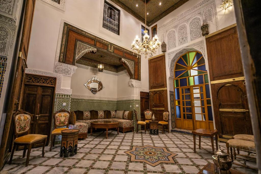 非斯Dar Usham Fes的一间配备有沙发、椅子和吊灯的客房