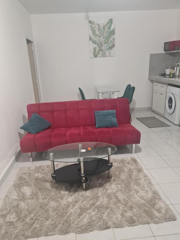 马罗尼河畔圣洛朗Résidence DENGUELE的客厅里一张红色的沙发,配有桌子