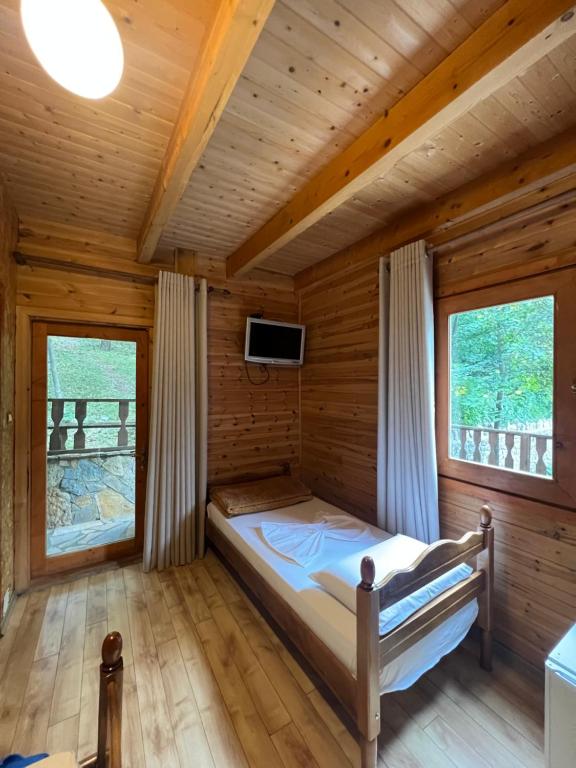 RazëmVila Pepaj Razem的木间内的一张床位,设有两个窗户
