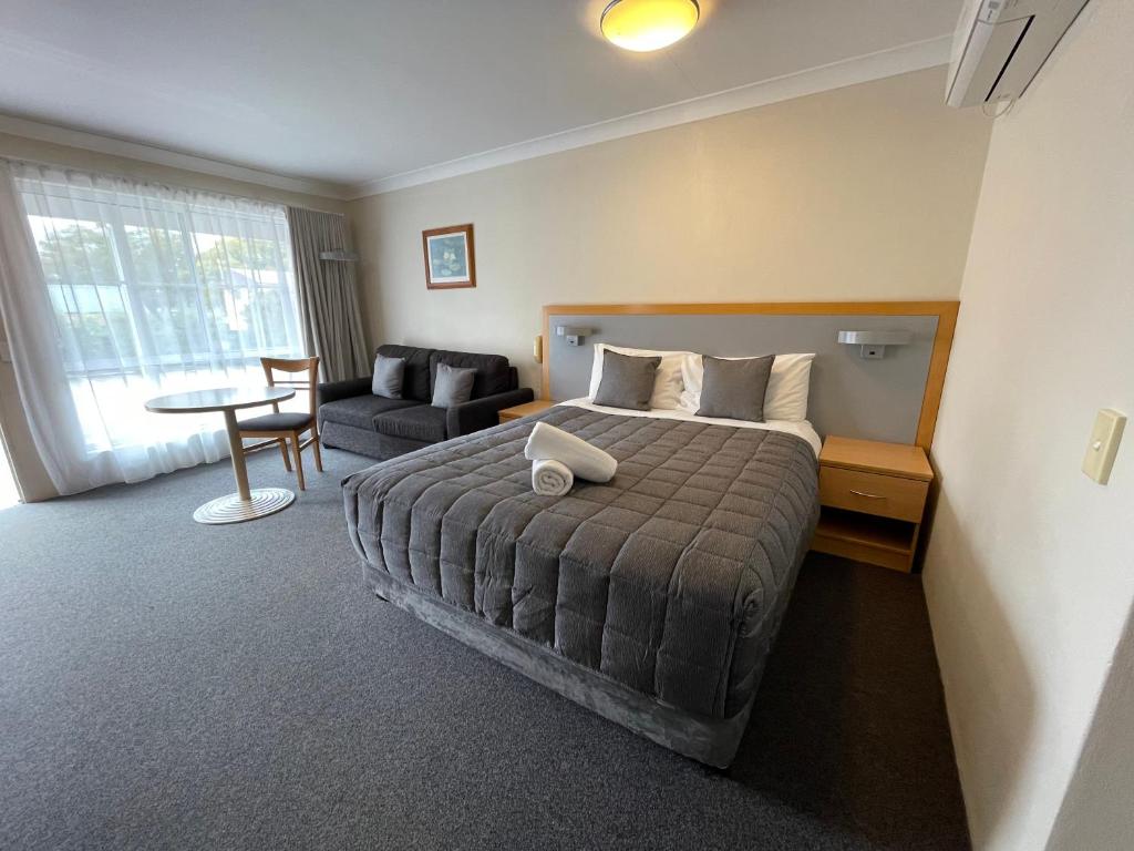诺拉乔治巴斯汽车旅馆的一间卧室配有一张床、一张沙发和一张桌子