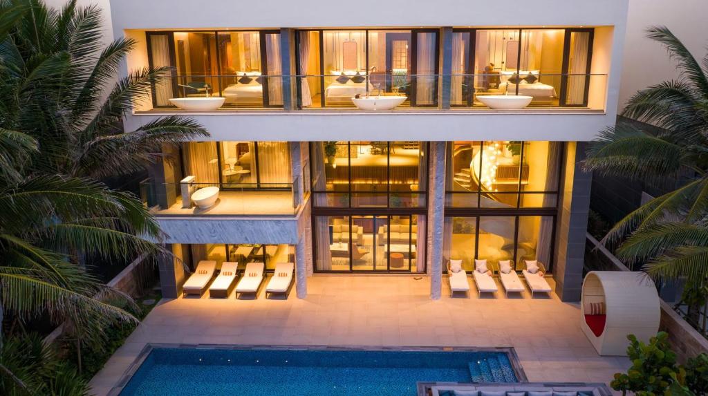 会安The Five Villas & Resort Quangnam - Danang的一座带游泳池和许多窗户的房子