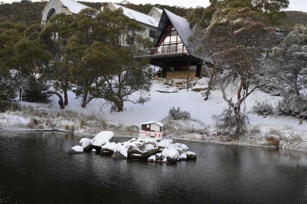 斯瑞德伯姆恩巴滑雪山林小屋的雪中河中的房子