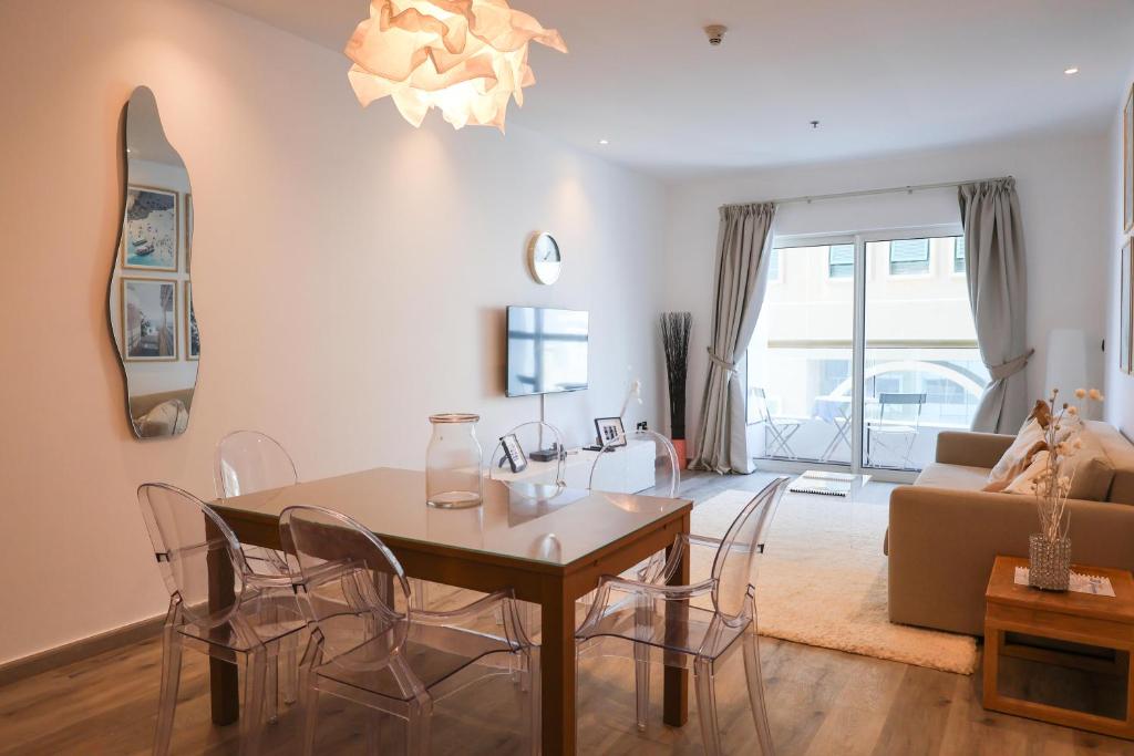 迪拜Deluxe 1 Bedroom Apartment - Elite Residence Dubai Marina - Sea View的客厅配有桌椅和沙发