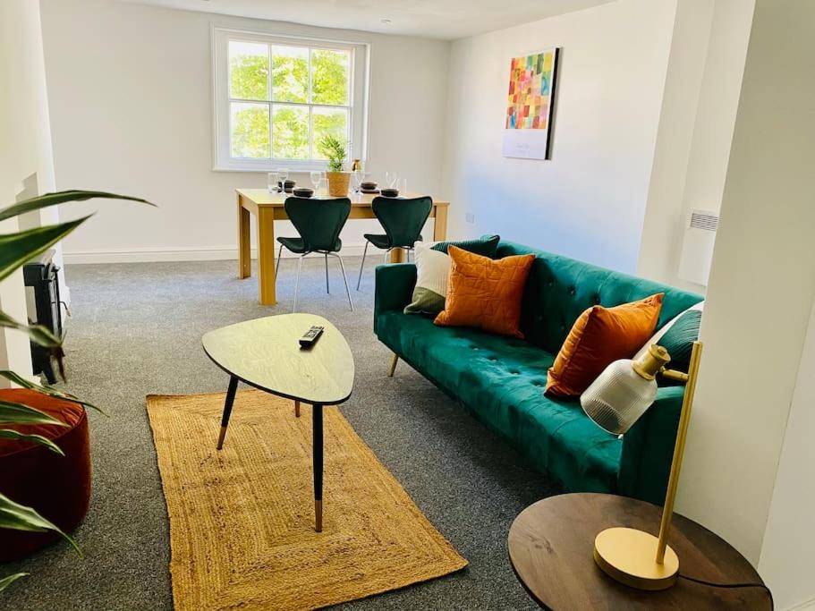 格洛斯特Penthouse - Contractors Professionals的客厅配有绿色沙发和桌子