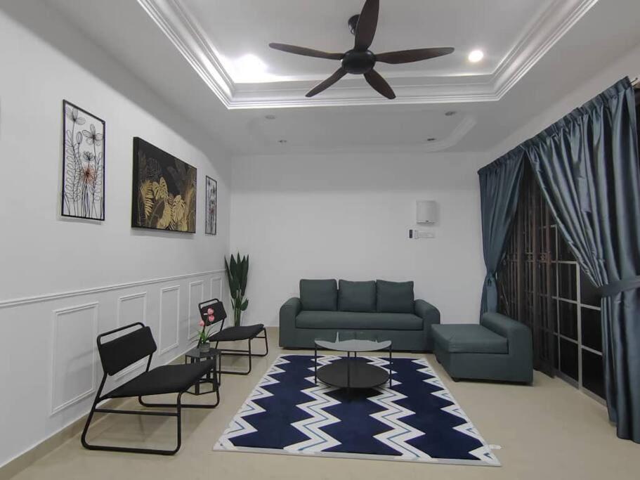 而连突D'Sroja Home in Jerantut的客厅配有沙发、椅子和吊扇