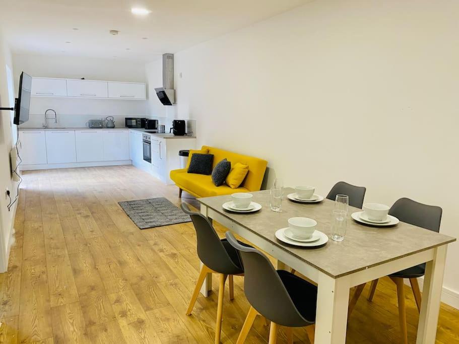 格洛斯特Ten - Central Apartment - Contractors Professionals的用餐室以及带桌椅的厨房。