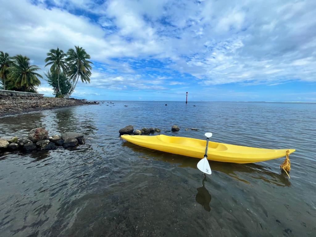 帕帕拉Tahiti - Kea Lodge的坐在海滩旁的水面上的黄色小船