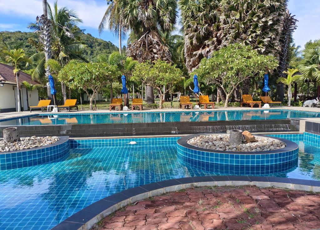 苏梅岛Garto Resort的一个带椅子和树木的度假村游泳池