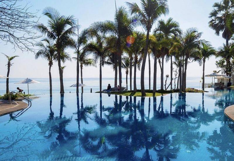 华欣Baan Sanploen. Unit 244的一座棕榈树环绕的游泳池