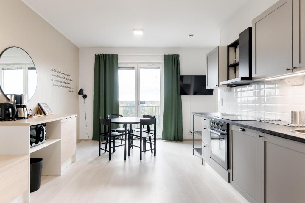 康阿斯阿拉Serviced Apartments Kuohu Kangasala by UHANDA的厨房配有白色橱柜和桌椅