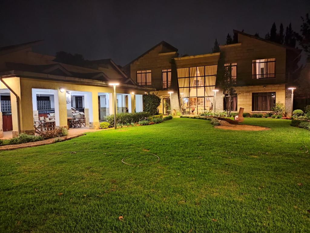 内罗毕Florances Rest House的夜晚有绿色庭院的房子