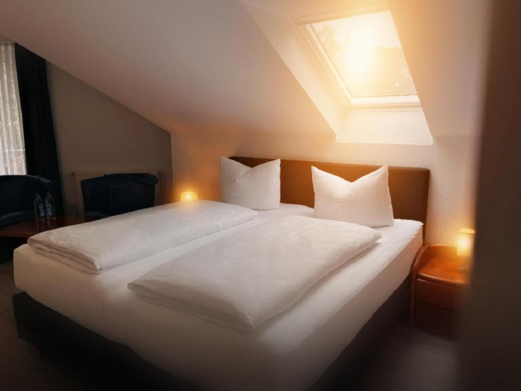林根Appart-Haus Business Apartments的卧室配有一张带白色床单和枕头的大床。