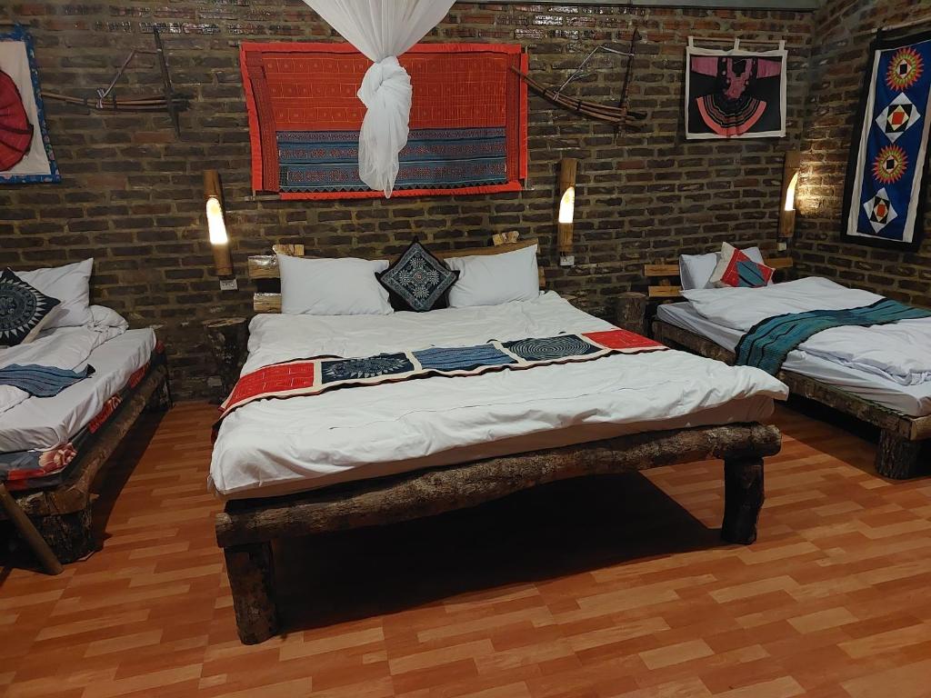 和平A La Homestay的一间卧室设有两张床和砖墙
