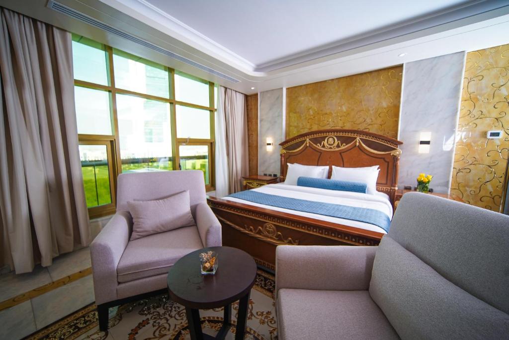 阿布扎比AG酒店的酒店客房,配有一张床和两把椅子