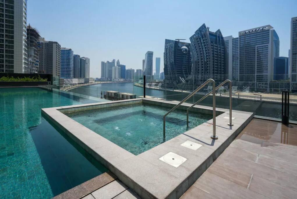 迪拜Meerak Homes - Glamorous 2 bed Apartment with Panoramic Views - Business Bay with free Wifi, Parking, Gym and Pool的建筑物屋顶上的游泳池