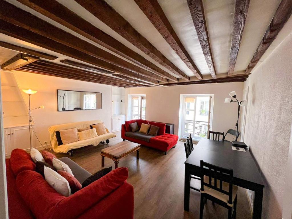 巴黎Charming two-room apartment near Montparnasse的客厅配有红色的沙发和桌子