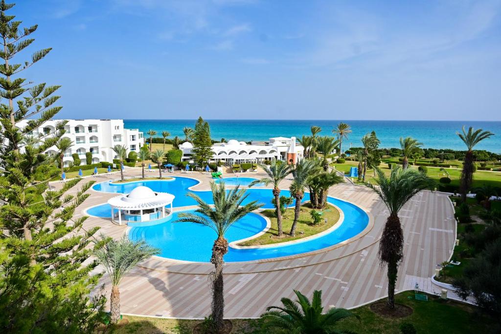 马赫迪耶Mahdia Palace Thalasso的享有带游泳池和海洋的度假村的空中景致