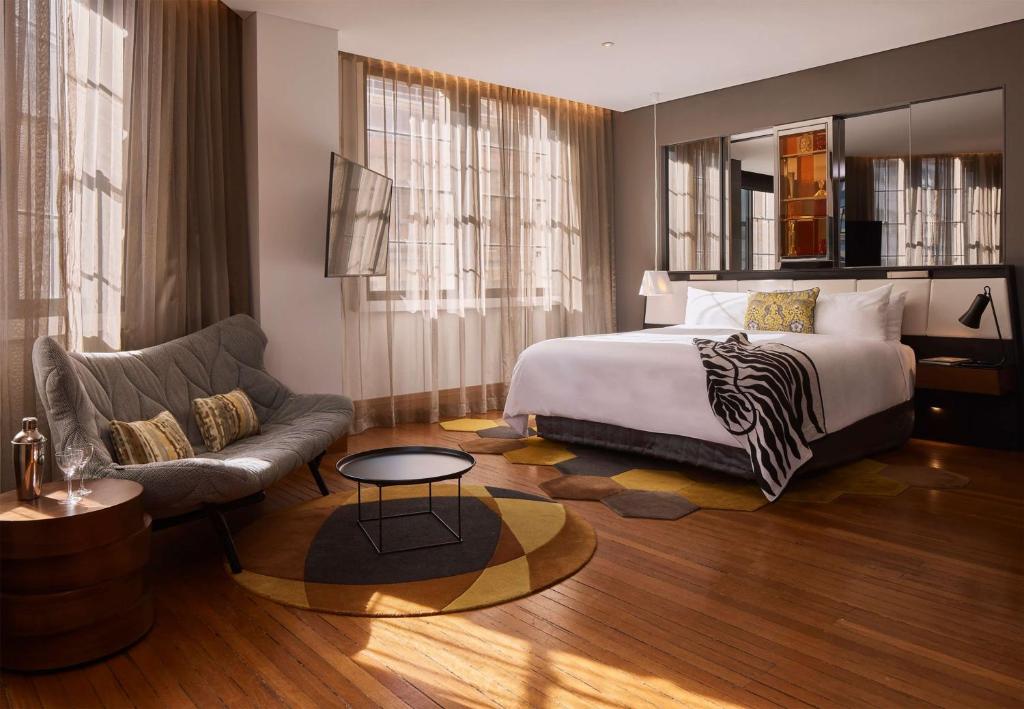 悉尼悉尼QT精品酒店的酒店客房,配有床和沙发