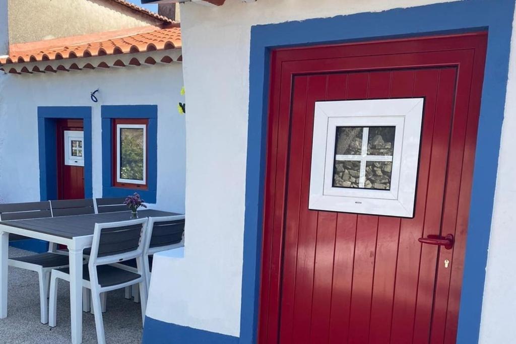 法蒂玛Casa Manuel e Maria的红门和房子前面的桌子