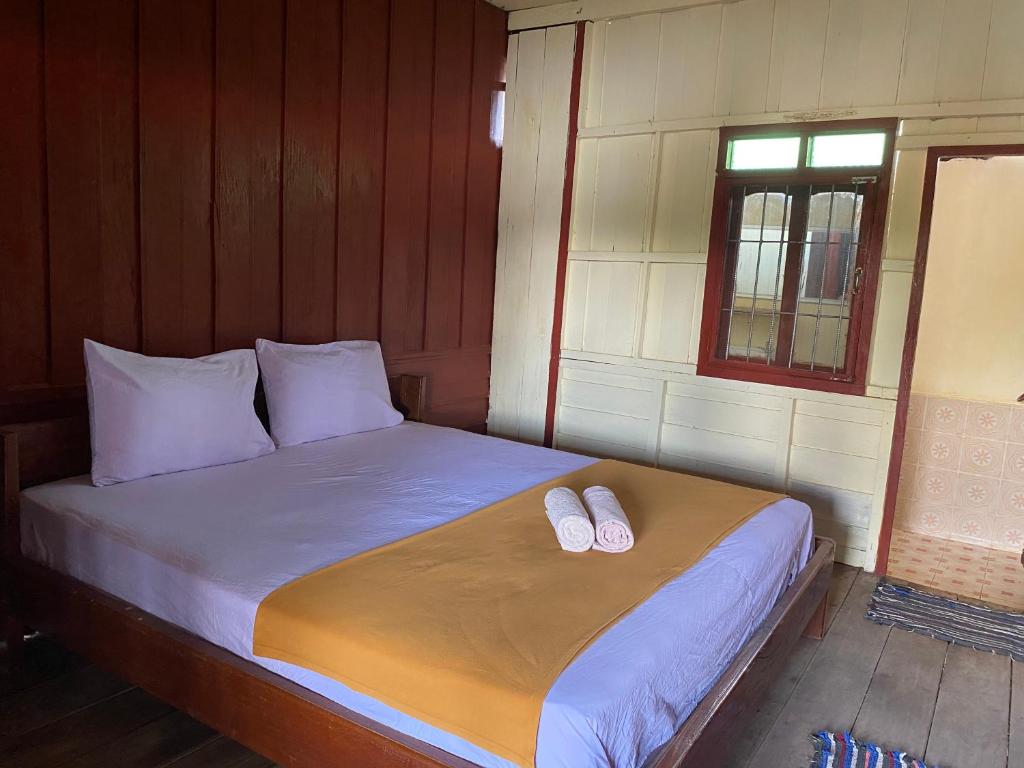 Ban DonsômSouksanh Guesthouse的一间卧室配有一张床,并备有2个拖鞋