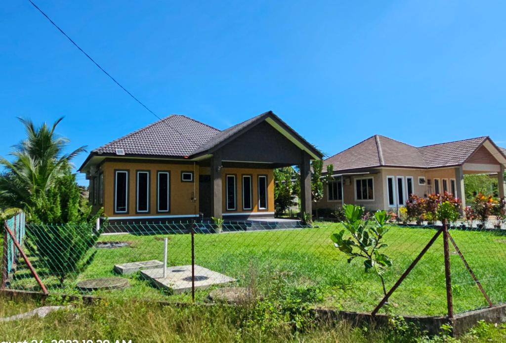 巴佐Homestay Rumah Tengok Jelawat Bachok的前面有绿色草坪的房子