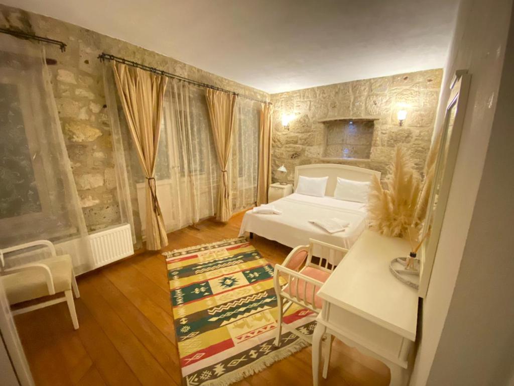 阿拉恰特MaSaLa Otel的卧室配有一张床和一张桌子及椅子