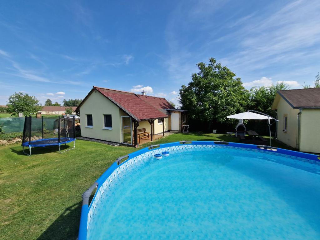 Holiday Home Velký Ratmírov by Interhome的一座带房子的庭院内的游泳池